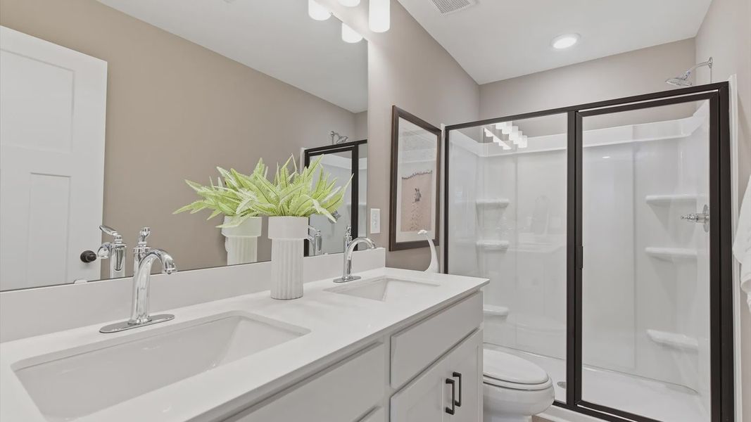 Churchill Design primary bath featuring dual vanity, walk-in shower, and tasteful design touches throughout