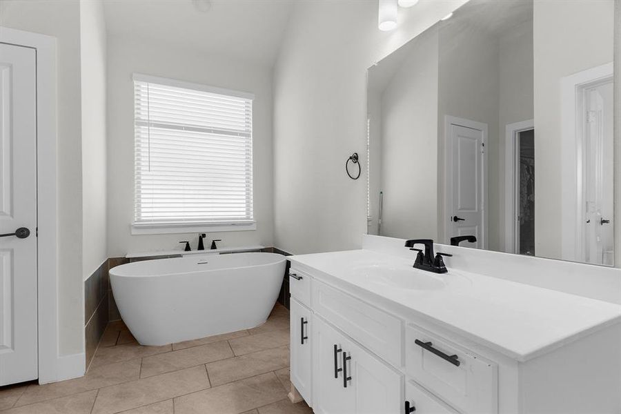 Bathroom with vanity, a soaking tub, and tile patterned flooring Bathroom with vanity, a soaking tub, and tile patterned flooring