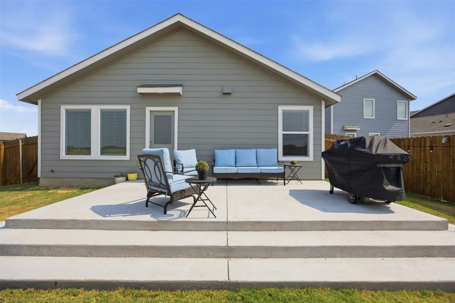 A spacious concrete patio stretches across the back of this modern siding home.