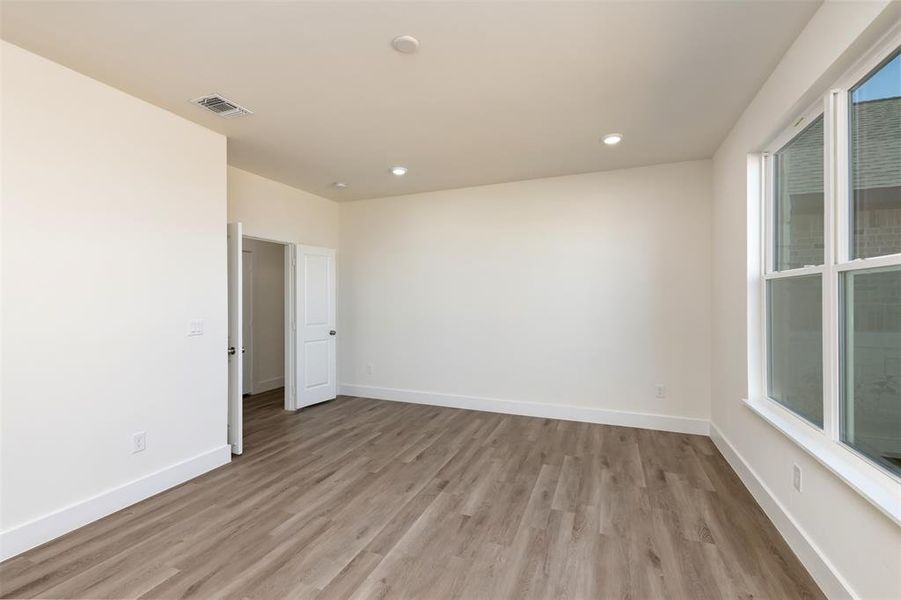 Unfurnished room with baseboards, visible vents, light wood-style flooring, and recessed lighting