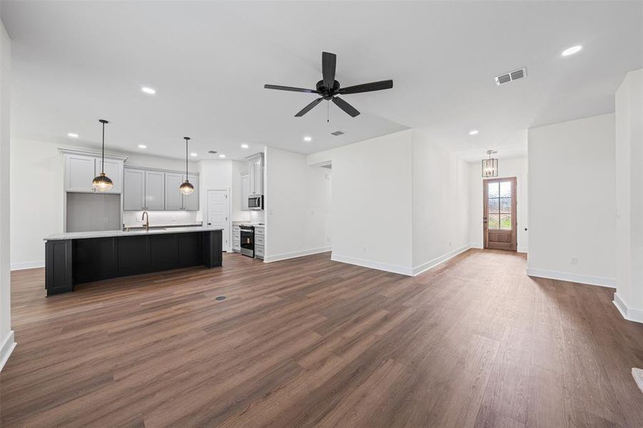 Open concept living area featuring wood flooring, recessed lighting, and a ceiling fan