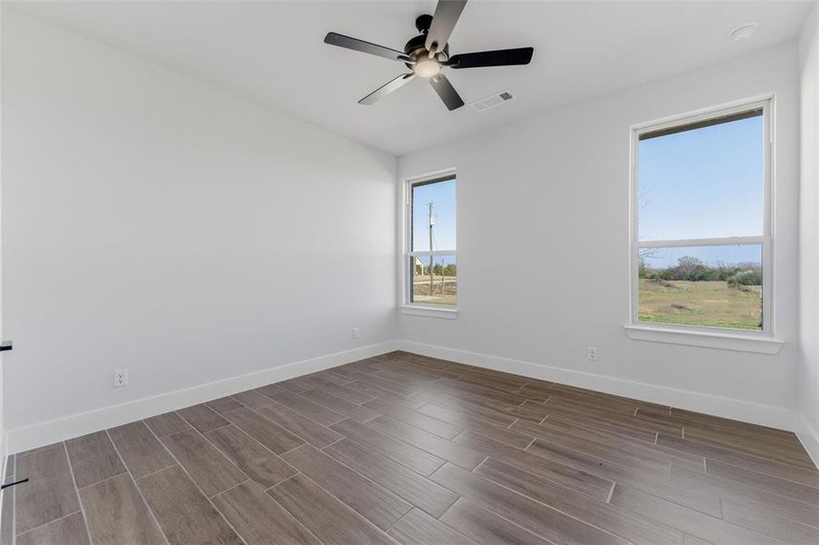 Spare room featuring wood tiled floors and a ceiling fan