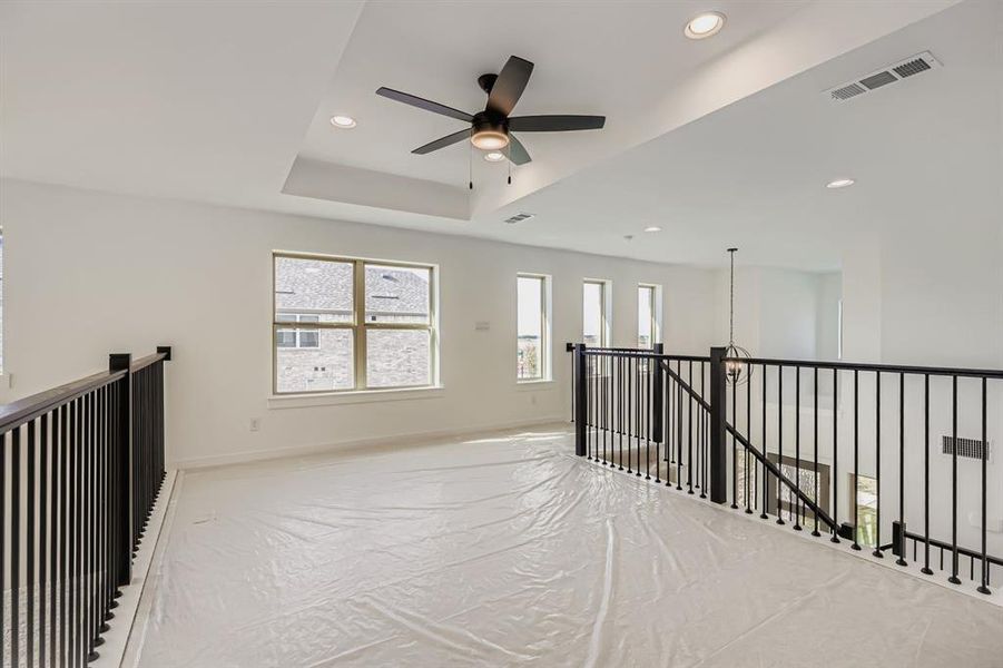 Hall featuring an upstairs landing, a tray ceiling, and recessed lighting Hall featuring an upstairs landing, a tray ceiling, and recessed lighting