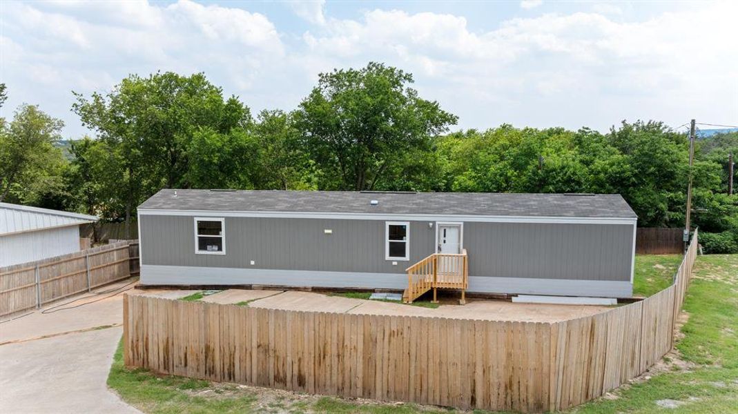 Gray exterior siding with white trim, featuring a dark shingle roof