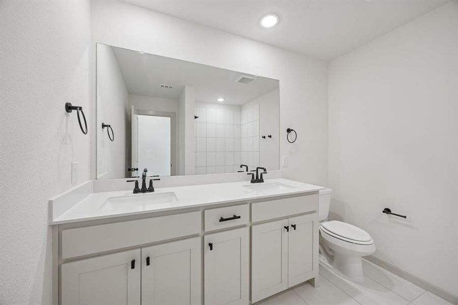 Guests will enjoy their own vanity space in this thoughtfully designed guest bath.