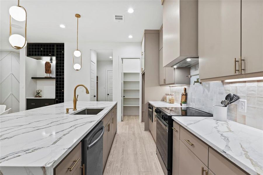 Kitchen with sink, gray cabinetry, hanging light fixtures, black range with electric cooktop, and wall chimney exhaust hood