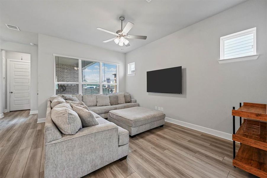 Living area featuring ceiling fan and light wood finished floors Living area featuring ceiling fan and light wood finished floors