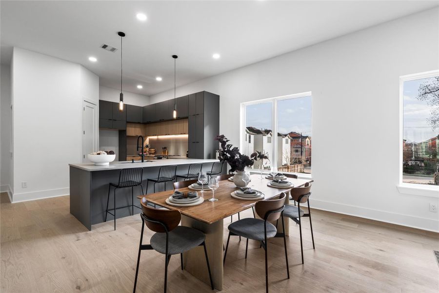Unfolding beneath airy ceilings and grounded by pale engineered oak, the dining area is a seamless extension of the kitchen’s architectural rhythm.Defined by clean sight lines and natural light, this space invites both casual gatherings and elevated hosting. Whether it’s weekday takeout or a ten-person dinner party, the atmosphereremains effortlessly composed