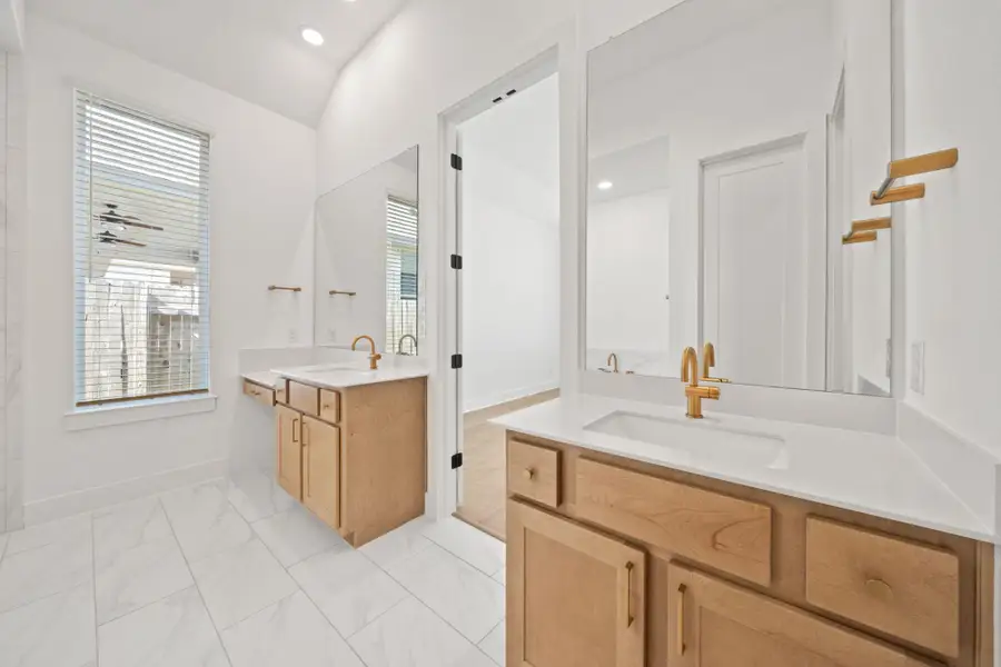 Full bathroom with two vanities, recessed lighting, light marble finish floors, and a ceiling fan