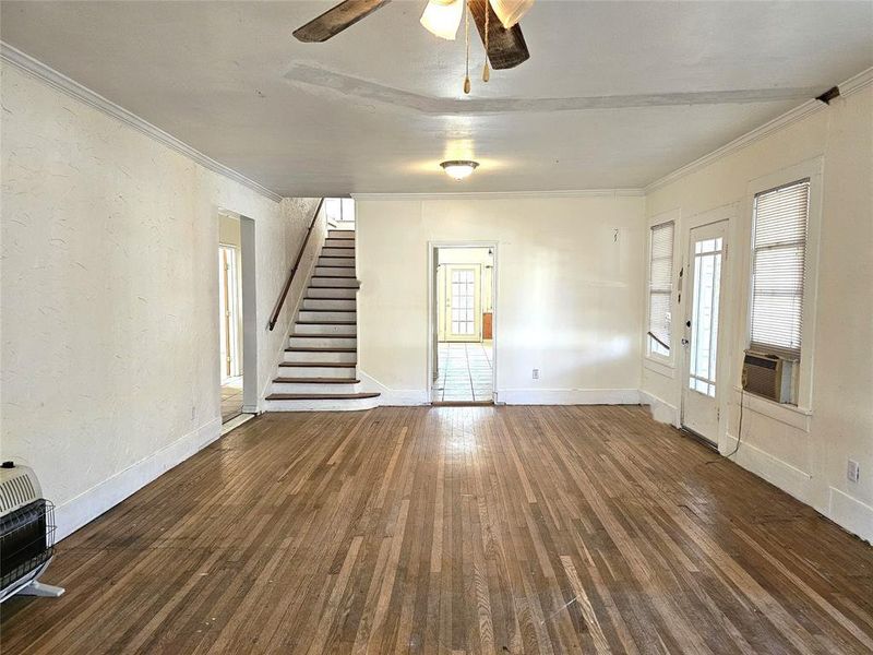 Unfurnished living room featuring heating unit, dark hardwood / wood-style floors, crown molding, and ceiling fan Unfurnished living room featuring heating unit, dark hardwood / wood-style floors, crown molding, and ceiling fan