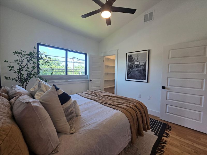 High vaulted ceilings and rich hardwood flooring define this comfortable bedroom space.