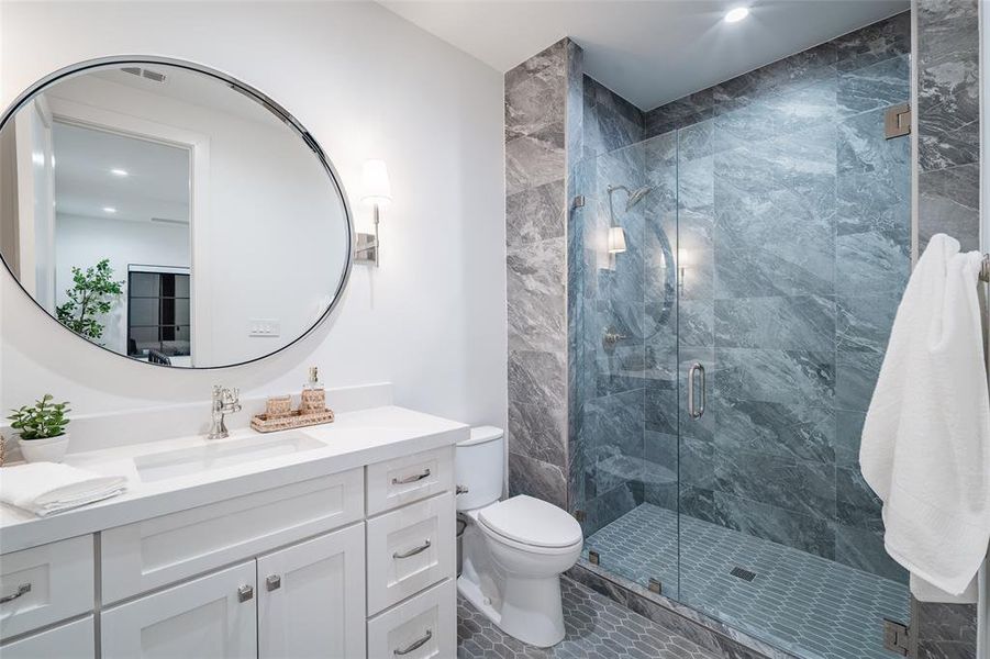 Bathroom with tile patterned flooring, vanity, an enclosed shower, and toilet