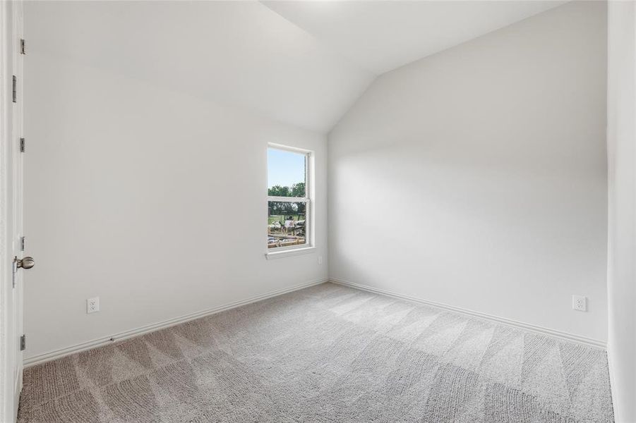 Interior room featuring a single-pane window, neutral-toned walls, and sloped ceiling Interior room featuring a single-pane window, neutral-toned walls, and sloped ceiling