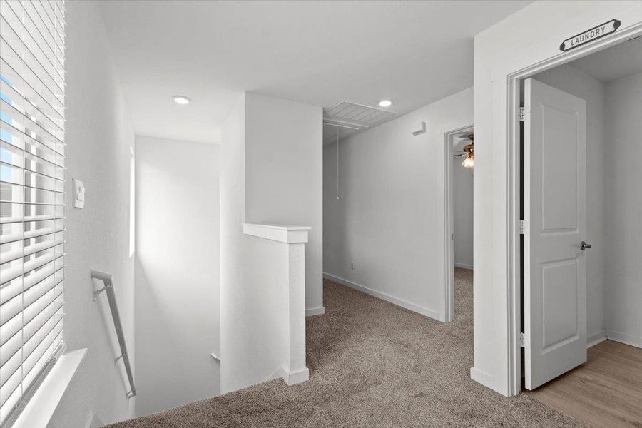 A well-lit landing on the upper floor provides convenient access to a dedicated laundry area.