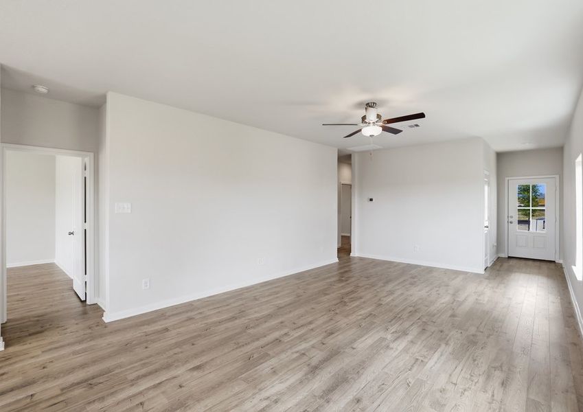 Living room featuring a ceiling fan and an open sightline to the kitchen.