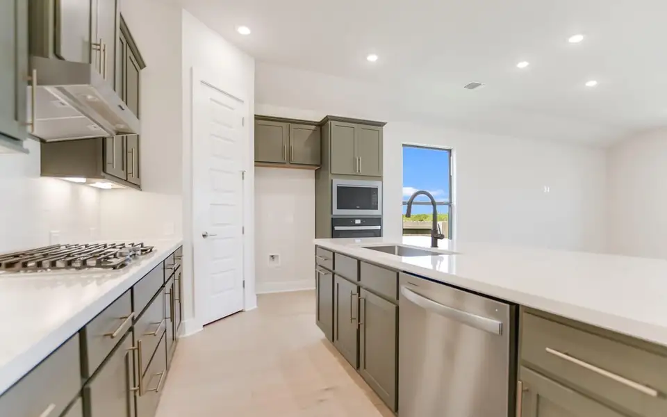 Kitchen featuring recessed lighting, stainless steel appliances, and light stone counters