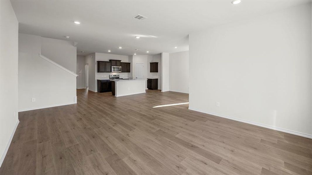 Unfurnished living room featuring recessed lighting and dark wood finished floors