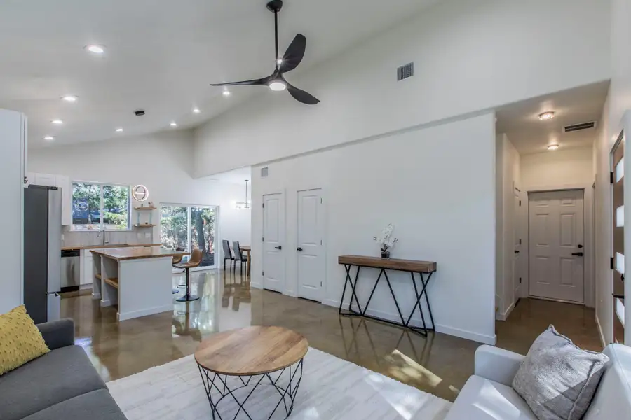 Living room featuring high vaulted ceiling, concrete flooring, a ceiling fan, and recessed lighting