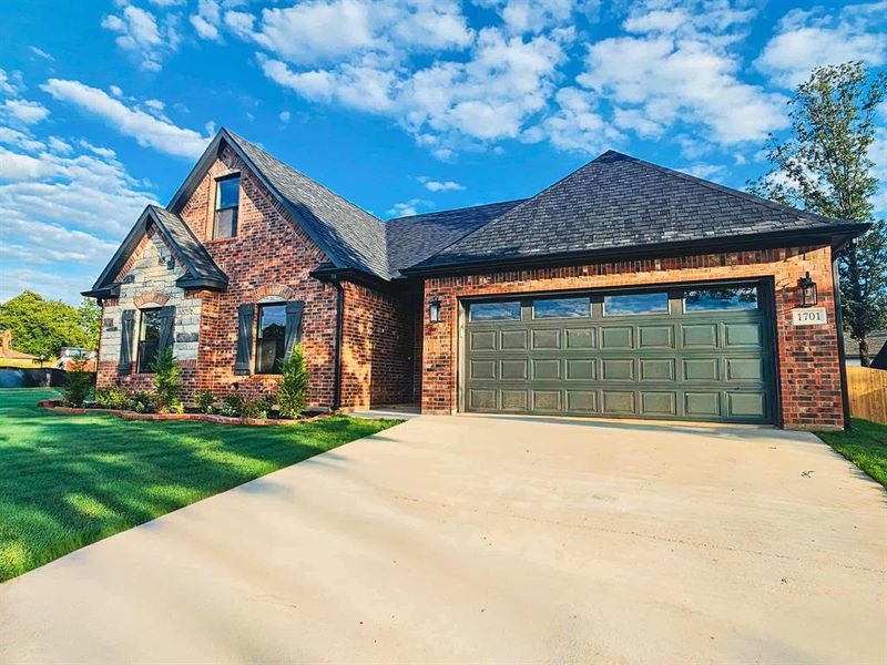 Beautiful brick + stone home w/ garage and wood fence.