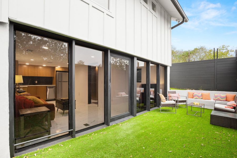 Lower entrance to the bottom unit with an outdoor hangout area and board and batten siding