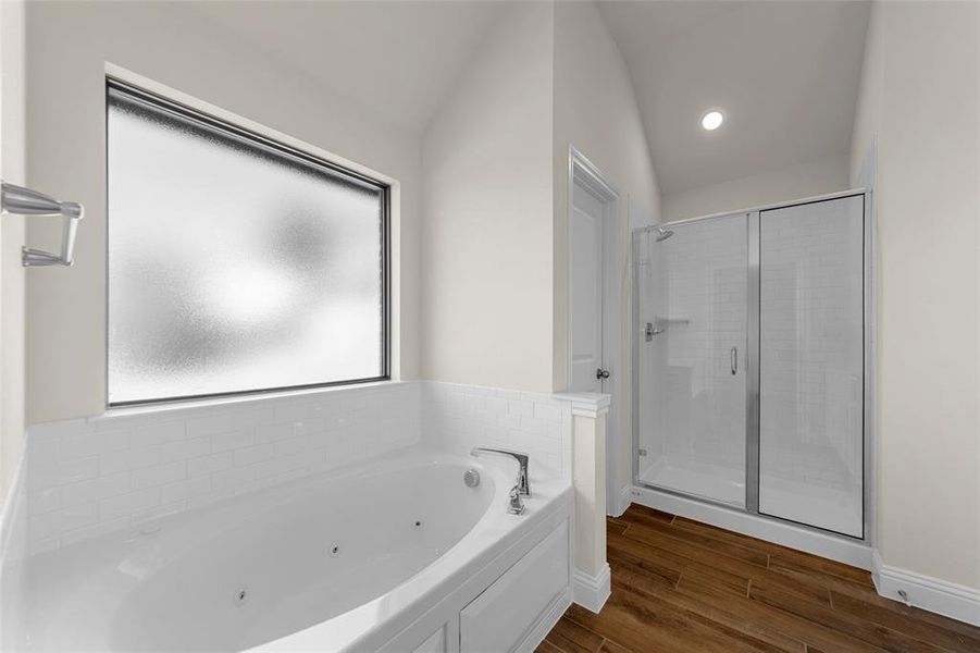 Full bath featuring a tub with jets, a shower stall, and dark wood-style flooring