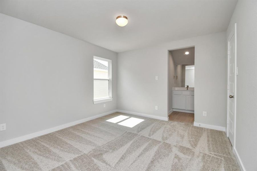 Secondary bedroom features plush carpet, custom paint, large window with privacy blinds and access to the Jack and Jill bath.