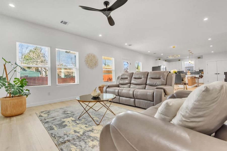Living area featuring a ceiling fan, recessed lighting, plenty of natural light, and light wood-type flooring