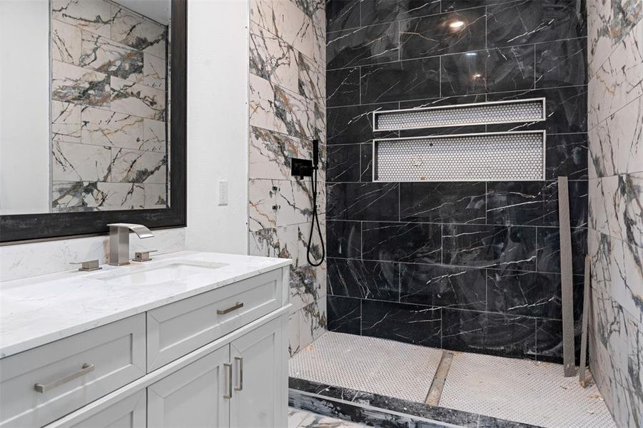 Bathroom with vanity and a tile shower