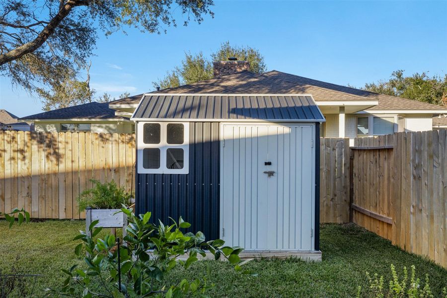Charming backyard includes a convenient storage shed.