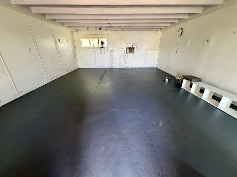 A spacious Craft/utility room offers durable flooring and exposed ceiling joists, ideal for various functional uses.