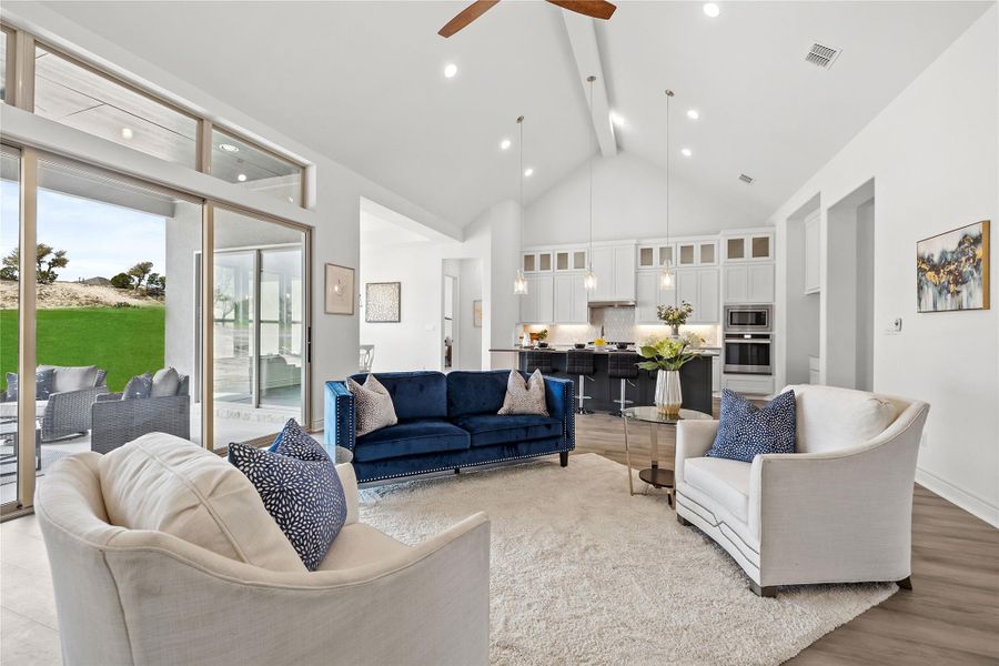 Living area with beam ceiling, ceiling fan, high vaulted ceiling, light wood-style floors, and recessed lighting