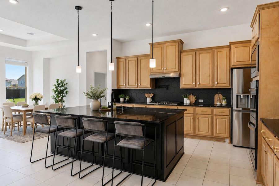 Gorgeous kitchen comes equipped with stainless steel appliances, beautiful natural wood cabinetry, granite countertops, a large eat-in island, 100 percent sink with drinking water and soap fixtures, a great sized pantry tucked behind the stove, and a pot filler over the stove for convenience.