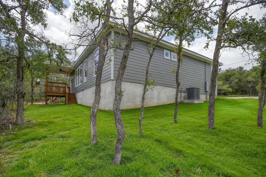 A verdant lawn frames the contemporary gray siding and elevated rear deck of this inviting residence. A verdant lawn frames the contemporary gray siding and elevated rear deck of this inviting residence.