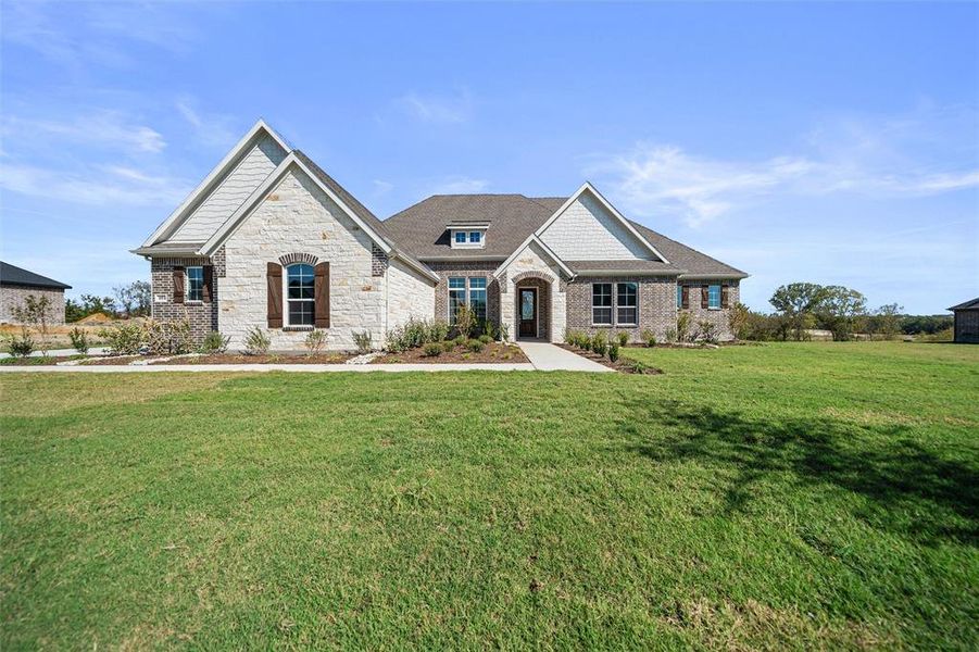 View of front of property featuring a front yard and stone siding View of front of property featuring a front yard and stone siding
