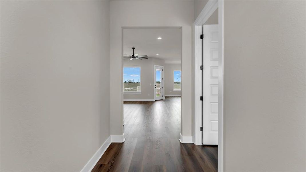 Rich wood-look flooring stretches from the entryway into a bright, open living space. Rich wood-look flooring stretches from the entryway into a bright, open living space.