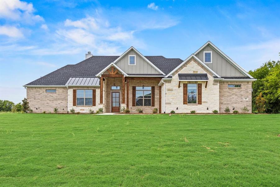 View of front facade featuring board and batten siding, covered porch, and a front yard View of front facade featuring board and batten siding, covered porch, and a front yard