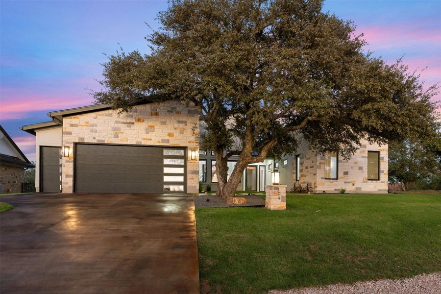 View of front of house featuring a garage and a yard