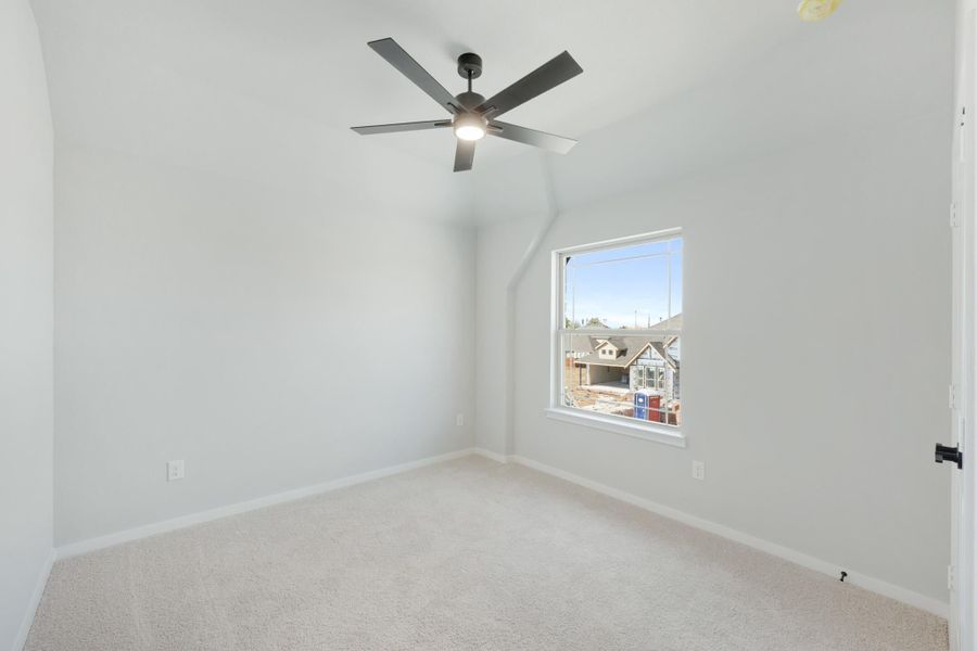 Empty bedroom with vaulted ceiling, ceiling fan, carpet flooring, and single window