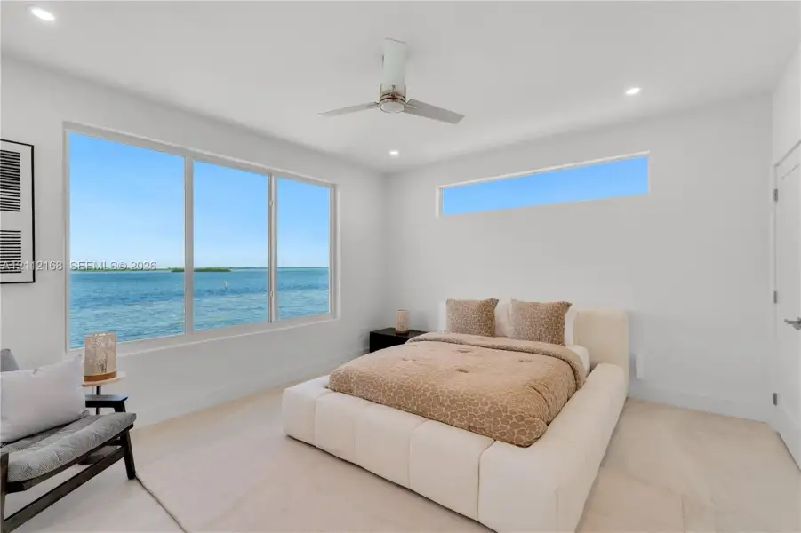 Large windows featuring water scenery, additional clerestory window, recessed lighting, and a modern ceiling fan Large windows featuring water scenery, additional clerestory window, recessed lighting, and a modern ceiling fan