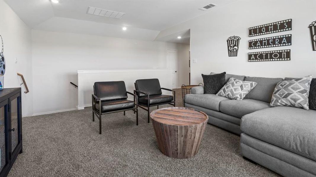 Carpeted living area with recessed lighting and baseboards