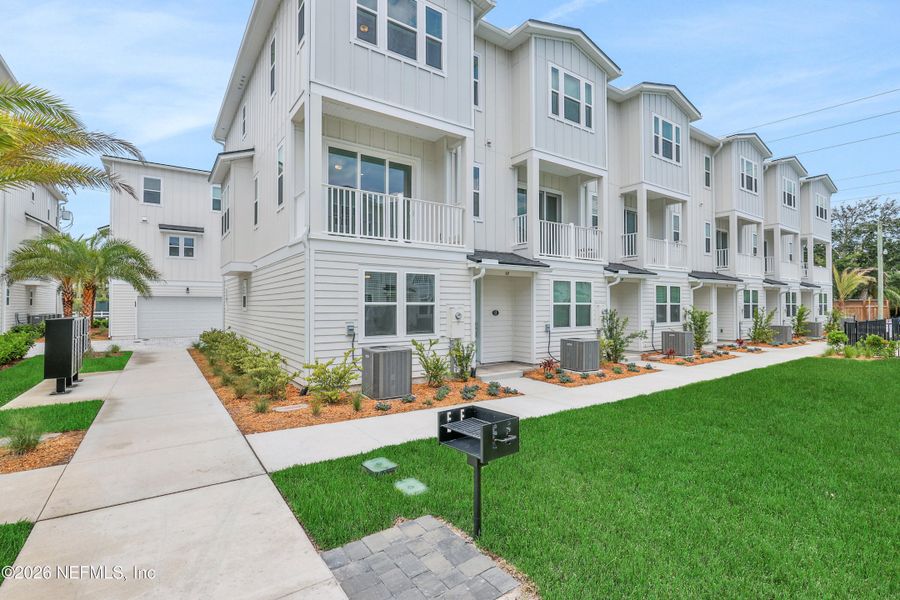 Front exterior of a new home in North Beach Townhomes, Jacksonville Beach, FL, highlighting curb appeal (Image 23). Front exterior of a new home in North Beach Townhomes, Jacksonville Beach, FL, highlighting curb appeal (Image 23).