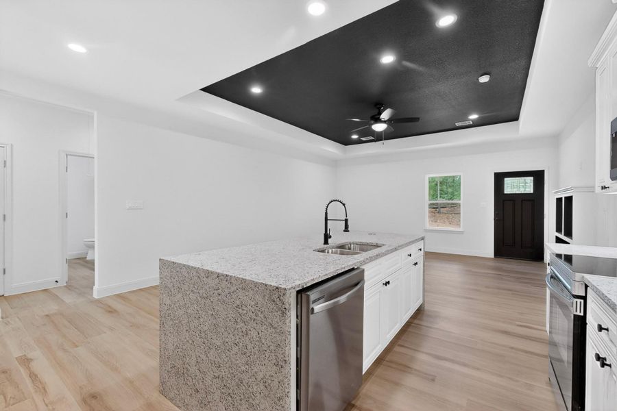 A contemporary kitchen space boasts a large island with granite counters and stainless steel appliances. A contemporary kitchen space boasts a large island with granite counters and stainless steel appliances.