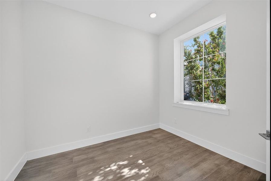 Empty room with wood finished floors and recessed lighting Empty room with wood finished floors and recessed lighting