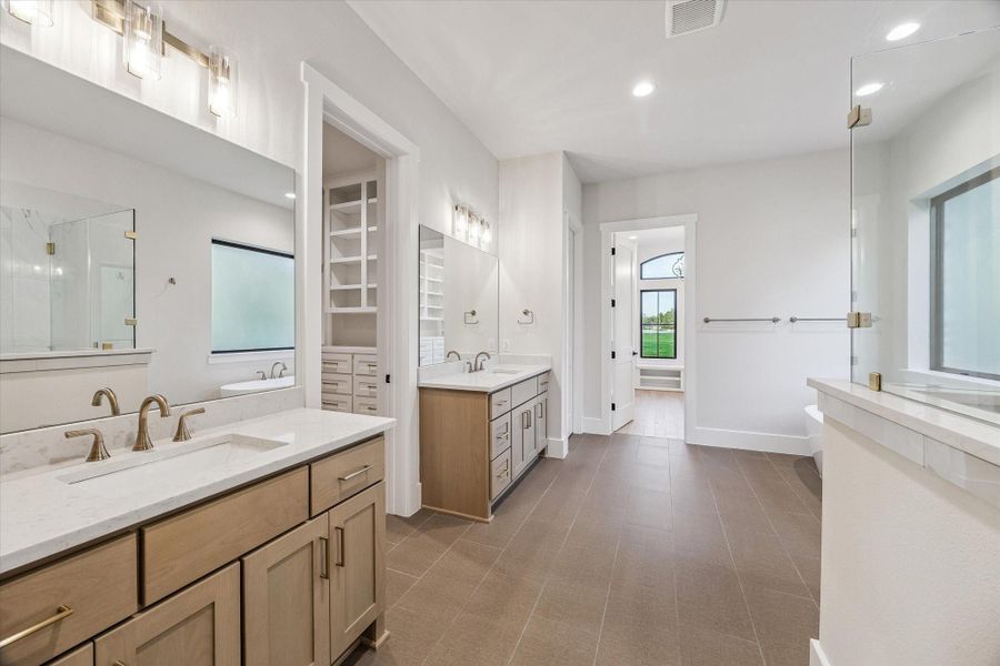 Primary Bath with separate vanities, deep soaking bathtub, and oversized walk-in shower. Primary Bath with separate vanities, deep soaking bathtub, and oversized walk-in shower.