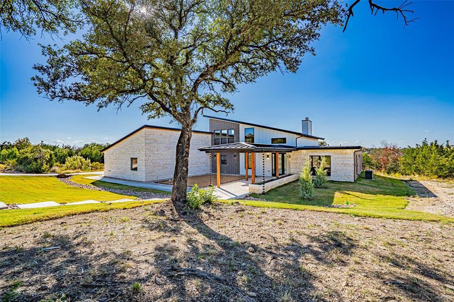 View of front of house featuring a front yard, a porch, a standing seam roof, stone siding, and a metal roof View of front of house featuring a front yard, a porch, a standing seam roof, stone siding, and a metal roof