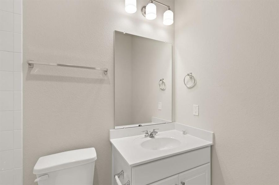 The secondary bath features tile flooring, white cabinetry and light countertops and a shower/tub combo. Perfect for accommodating any visiting family and friends.