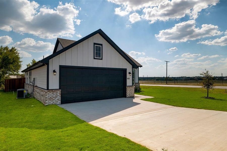 View of front of house featuring cooling unit, a front lawn, and a rural view
