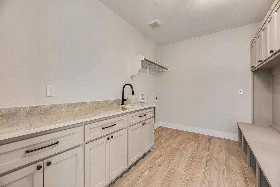 Laundry area with cabinet space, wood tiled floors, hookup for an electric dryer, and hookup for a washing machine