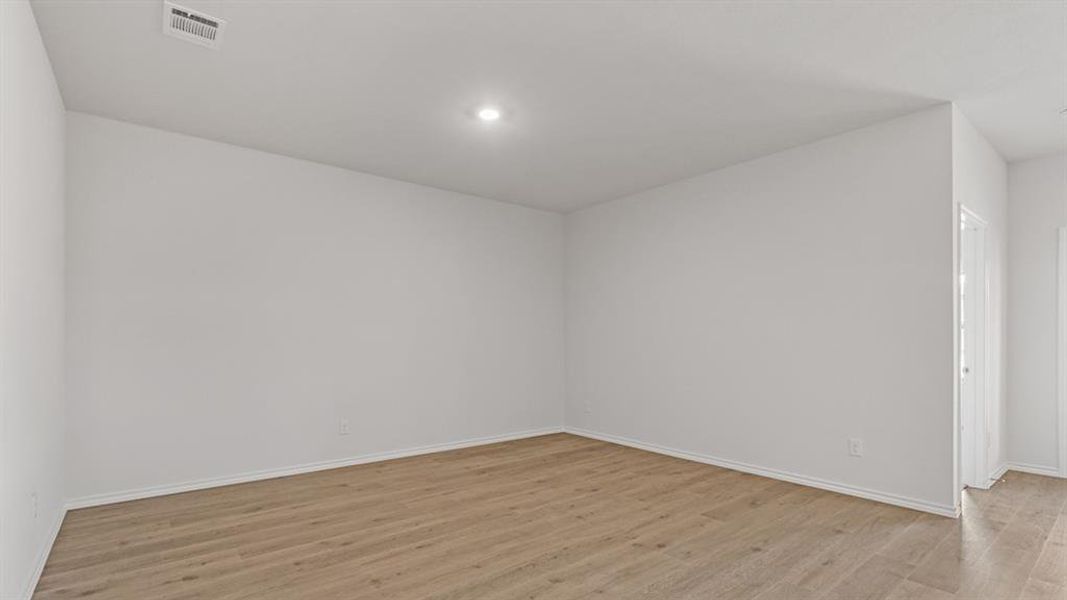 Empty room featuring light wood-type flooring and recessed lighting