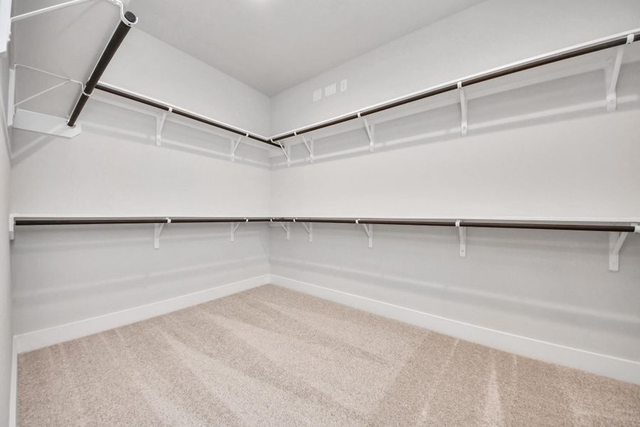 Walk-in closet that epitomizes luxury and practicality. This generously sized space features built-in shelving, offering abundant room for impeccable organization. High ceilings and recessed lighting create a bright and welcoming ambiance.